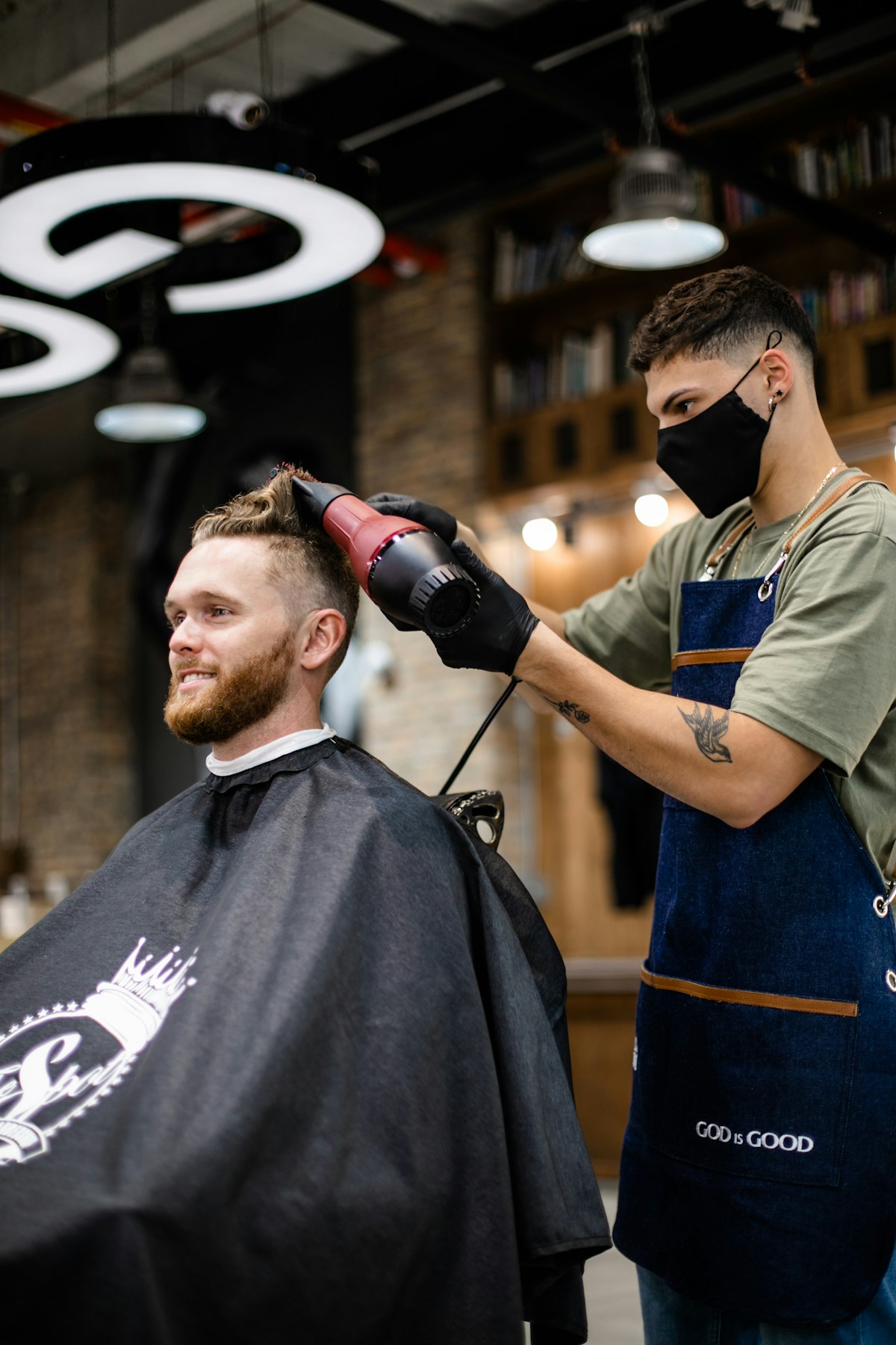 Barbeiro atendendo um cliente na barbearia